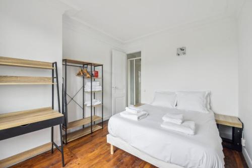 - une chambre avec un lit blanc et des serviettes blanches dans l'établissement 550 Suite Quinault - Superbe Appartement à Paris, à Paris