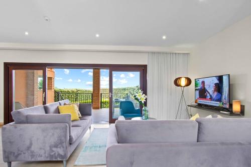 a living room with two couches and a tv at Vale de Milho Village in Carvoeiro