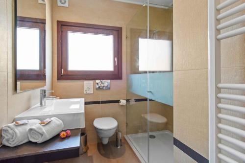 a bathroom with a sink and a toilet and a glass shower at Vale de Milho Village in Carvoeiro