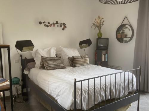 a bedroom with a bed with white sheets and pillows at Saint Marc Jaumegarde in Saint-Marc-Jaumegarde