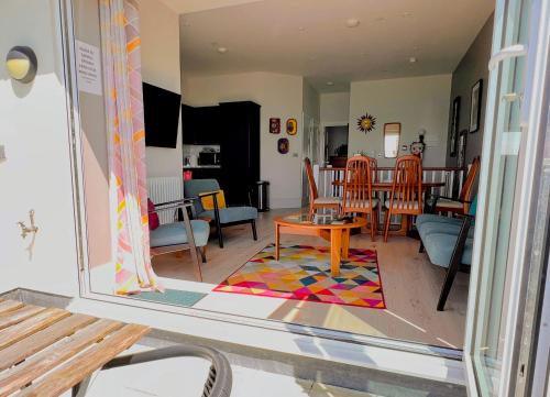 Seascape - 2 bedroom flat with panoramic sea views في Hollington: غرفة معيشة مع طاولة وغرفة طعام