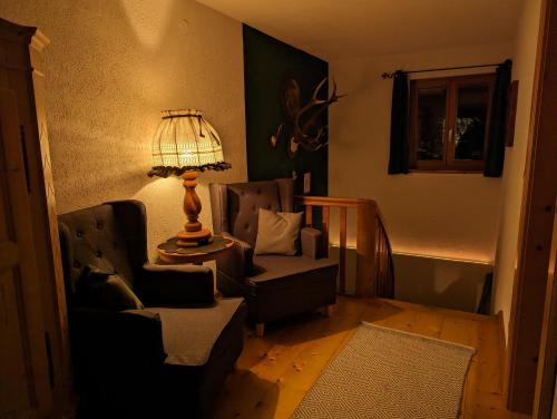 a living room with two chairs and a lamp at Der Wiesenhof in Krün