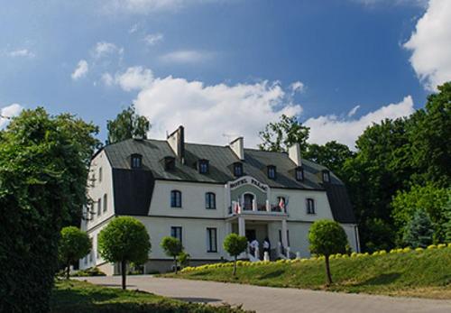 a large white house with a black roof at Hotel Pałac w Myślęcinku in Bydgoszcz