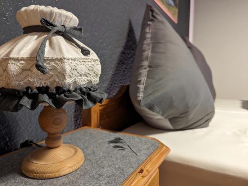 a lamp sitting on a table next to a pillow at Der Wiesenhof in Krün