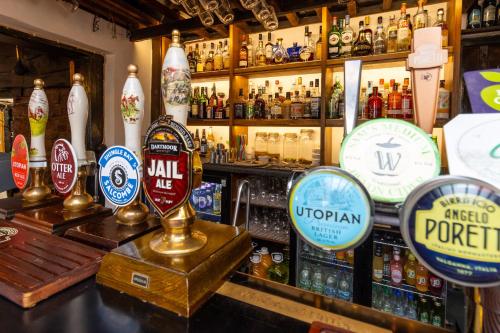 eine Bar mit vielen Bierkennzeichen auf der Theke in der Unterkunft New Inn in Crediton