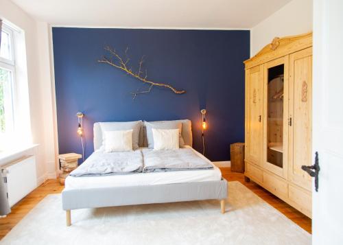 a bed in a room with a blue wall at Bake in Waabs