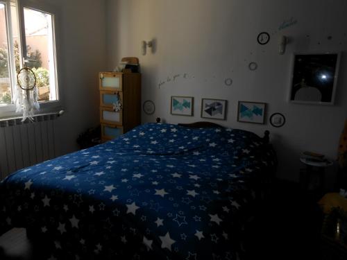 - une chambre avec un lit doté d'une couverture bleue avec des étoiles dans l'établissement Maison RomanEva, à Pélissanne