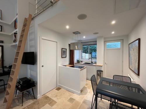 une cuisine et une salle à manger avec une table et des chaises dans l'établissement Loft avec terrasse et jardin, à Angoulême