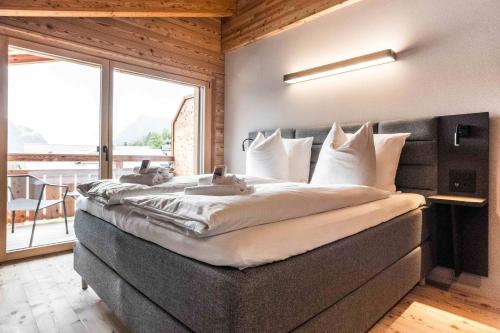 a large bed in a room with a large window at Apartment Neuenhaus 4.5 – GRIWA RENT AG in Grindelwald