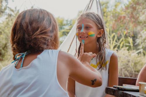 a young girl brushing her face in front of a mirror at Hotel Marinedda Thalasso & Spa in Isola Rossa