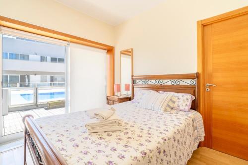 a bedroom with a bed and a large window at Oporto city and Beach apartment in Lavra