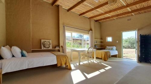 a bedroom with two beds and a table in it at Akasha Mountain Retreat, new location in Heidelberg