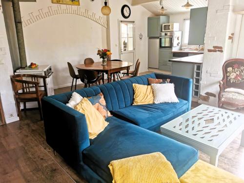 un salon avec un canapé bleu et une table dans l'établissement La fleur de l ile, à LʼÎle-dʼOlonne