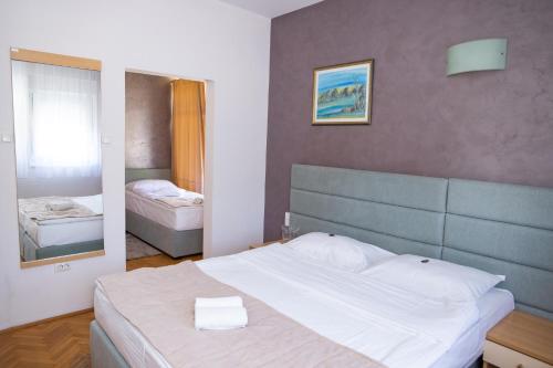 a bedroom with a large bed and a mirror at Motel New Sanatron in Bosanski Novi