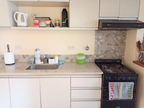 a kitchen with a sink and a stove top oven at Exclusivo y luminoso Estudio c/Balcón in Buenos Aires