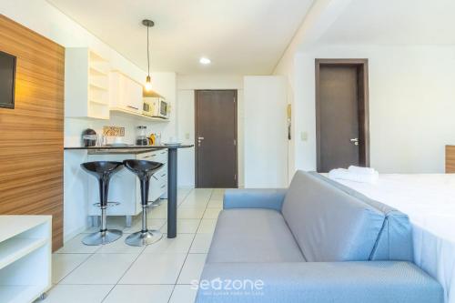 a living room with a couch and a kitchen at SPT - Studios Convenientes em Blumenau/SC in Blumenau
