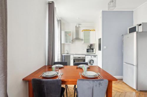 une cuisine avec une table en bois avec des chaises et un réfrigérateur dans l'établissement 554 Suite Laitière - Superbe appartement, à Vincennes