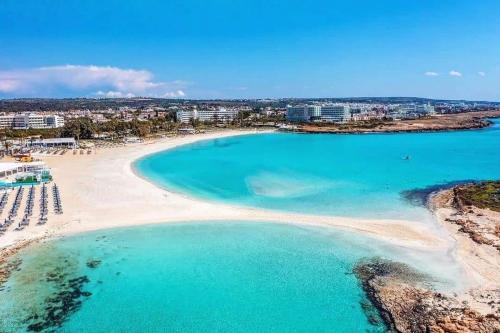 an aerial view of a beach with turquoise water at Nissi 3 Pool View 2 Bedroom Apartment with Large Veranda in Ayia Napa
