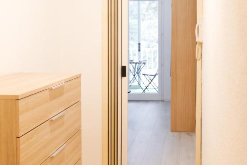 a kitchen with wooden cabinets and a view of a balcony at Studio au calme idéalement situé à Port Olona - La Chaume - 2 personnes in Les Sables-dʼOlonne