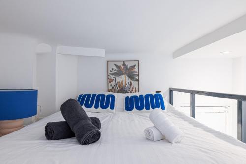 een wit bed met blauwe en witte handdoeken erop bij SMARTBNB - Moderne Studio - Zone Piétonne - Clim in Nice