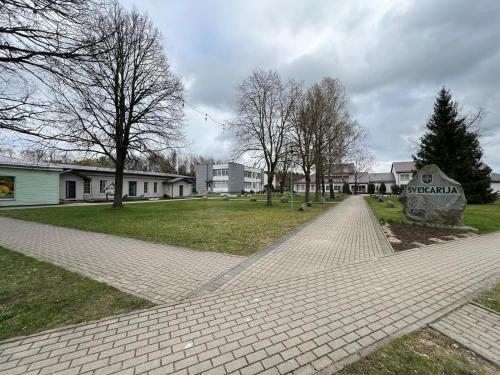 a brick walkway in a park with trees and buildings at Gabriel in Šveicarija