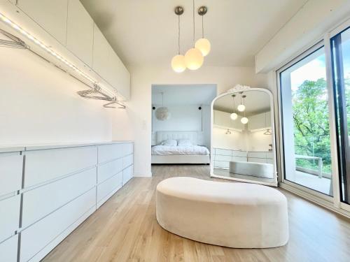 une pièce blanche avec un pouf blanc devant un miroir dans l'établissement Villa contemporaine d'architecte, à Bonneville