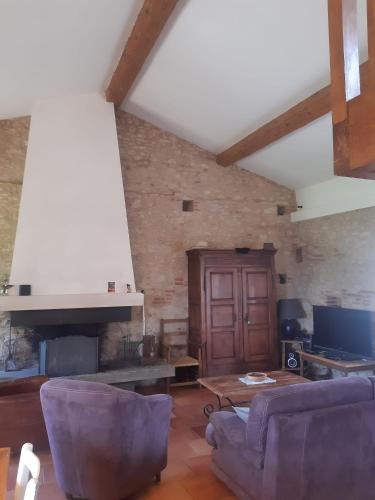 un salon avec un canapé et une cheminée dans l'établissement Le Pigeonnier au dessus du lac, à Caraman