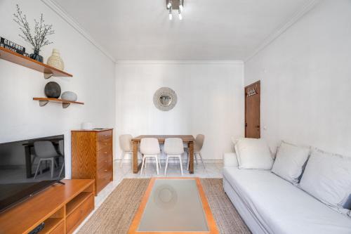 a living room with a white couch and a table at Hopstays - Almada Saudade in Almada