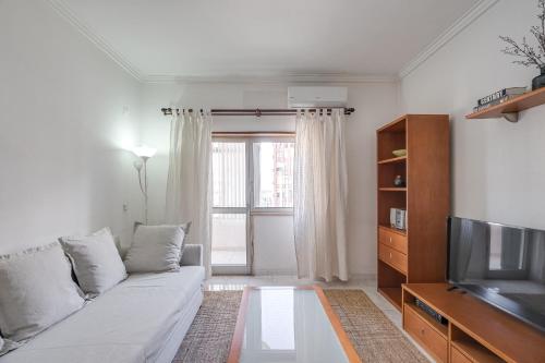 a living room with a couch and a television at Hopstays - Almada Saudade in Almada