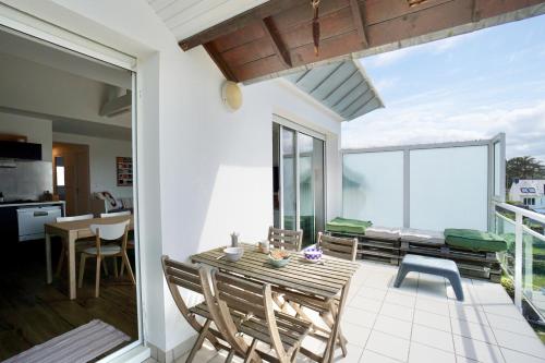 un patio avec une table et des chaises sur un balcon dans l'établissement Ollie Blue-50m de la plage, à Ploemeur