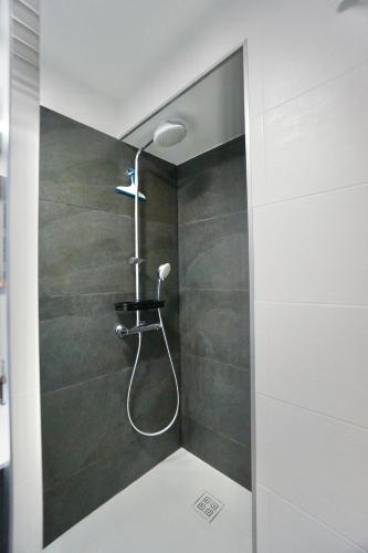 une douche avec pommeau de douche dans une salle de bain dans l'établissement Ollie Blue-50m de la plage, à Ploemeur