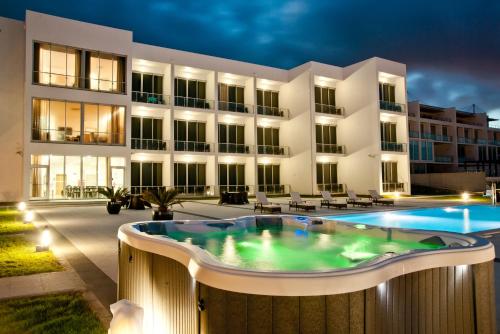 a building with a swimming pool in front of a building at Atlantida Mar Hotel in Praia da Vitória