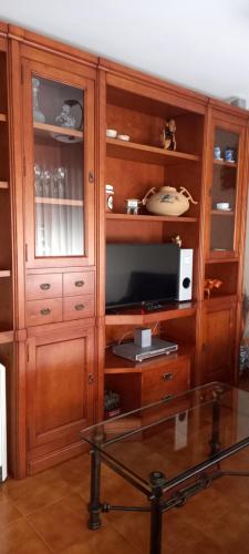 un gran armario de madera con TV. en Manuel Cortina 11, en Villaviciosa