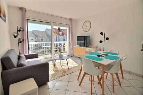 un salon avec un canapé et une table avec des chaises dans l'établissement Annonce professionnelle. T2 Cabine avec balcon, 4 personnes au cœur de la ville et à deux pas du sable chaud, à Hardelot-Plage