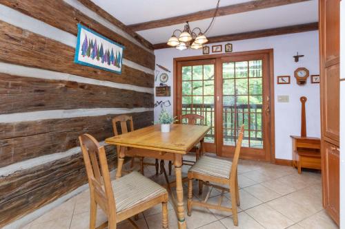 a dining room with a wooden table and chairs at Old Chestnut Cabin at Lake Junaluska in Waynesville