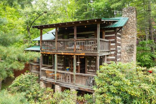 a large wooden house in the middle of the forest at Old Chestnut Cabin at Lake Junaluska in Waynesville