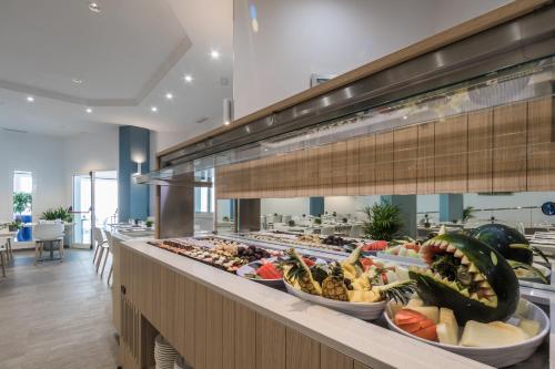 a buffet line with bowls of fruits and vegetables at Aparthotel Esquinzo Y Monte Del Mar in Playa Jandia