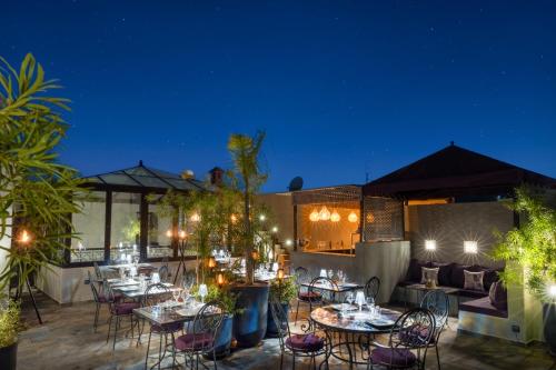 a patio with tables and chairs at night at Riad Sybil Boutique Hotel in Marrakech