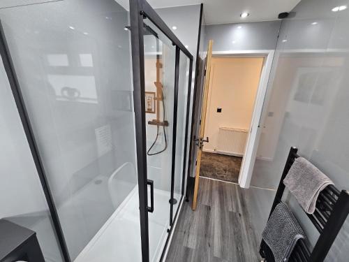 um quarto com uma porta de vidro que leva a um corredor em Modern Spacious walking distance to castle & town em Abergele