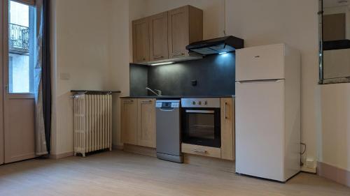 une cuisine vide avec un réfrigérateur et une cuisinière dans l'établissement Le Castel Médicis, à Le Mont-Dore