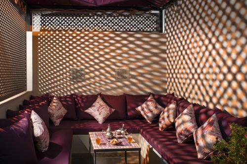 a red couch with pillows on it in a room at Riad Sybil Boutique Hotel in Marrakech
