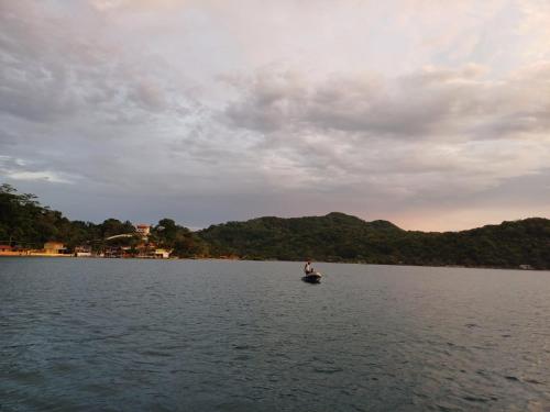 a person is on a boat in the water at Cabaña La Punta in Isla Grande