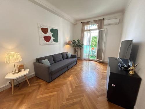 un salon avec un canapé et une télévision dans l'établissement Appartement 4 chambres face Gare Nice-ville, à Nice