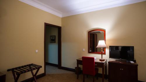 a hotel room with a television and a desk with a chair at The Villa 604 Powered by look in Cairo