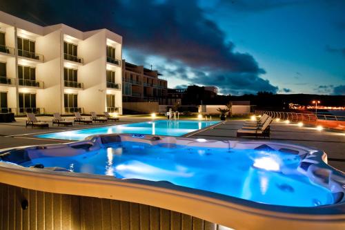 a hot tub on the balcony of a hotel at night at Atlantida Mar Hotel in Praia da Vitória