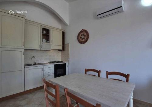a kitchen with a table and some chairs and a counter at La Ciaccia - appartement vue mer in La Ciaccia