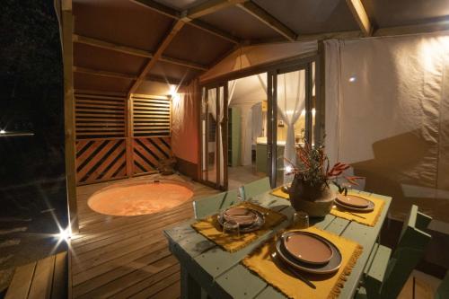 a room with a tub and a table with plates at Le Lenze Don Mimì Glamping in Mattinata