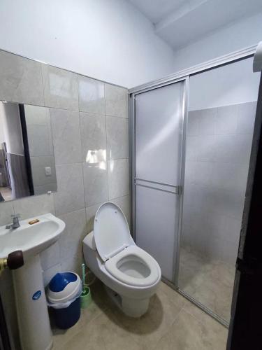 a bathroom with a shower and a toilet and a sink at Cabaña en condominio frente al mar #10 in Tolú