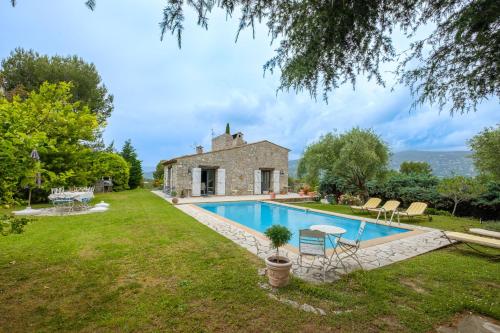 an external view of a house with a swimming pool at Villa Cyprès Bleu in Peymeinade