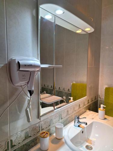 a bathroom with a sink and a large mirror at Casa Branca Pinhal in Nazaré